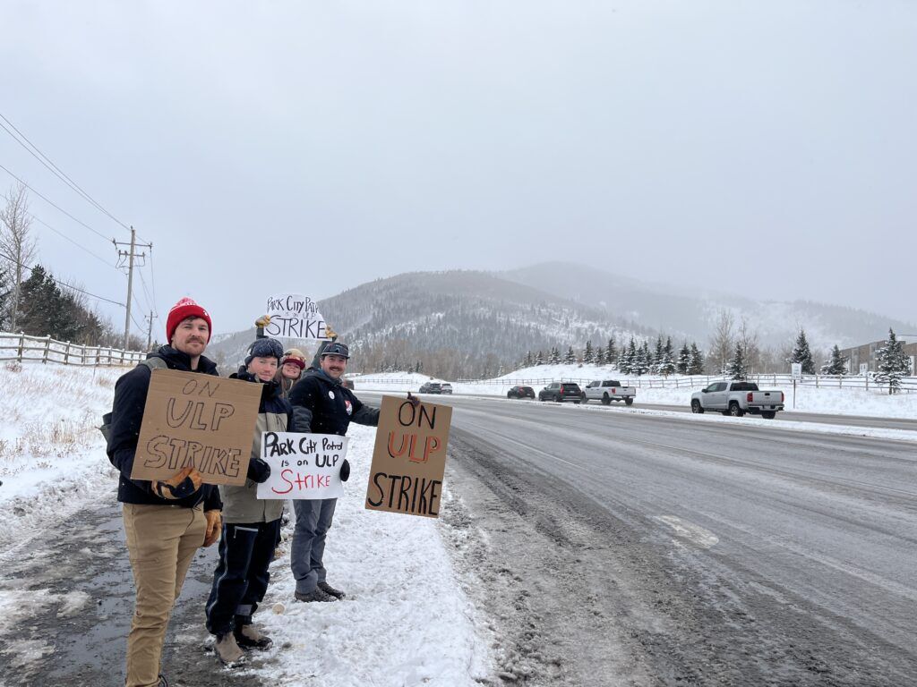 Park City Mountain ski patrollers form a picket line during their strike at Canyons Village, raising awareness of ongoing labor negotiations.