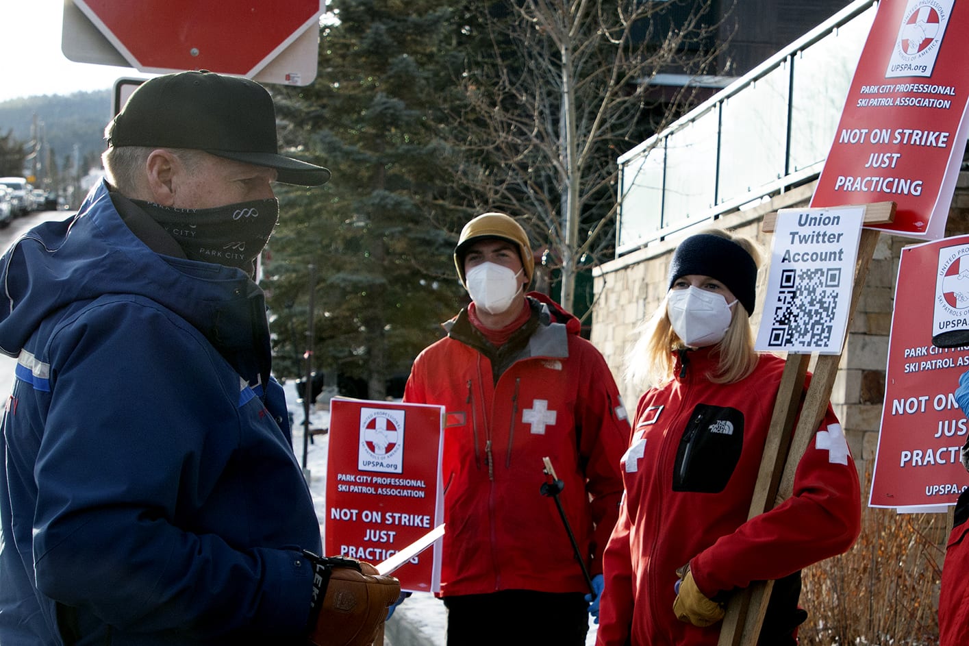 Members of the Park City Professional Ski Patrol Association (PCPSPA) Max Magill (left) and Melinda Behum (right) speaking with Mike Goar, COO of Park City Mountain, during the demonstration today.