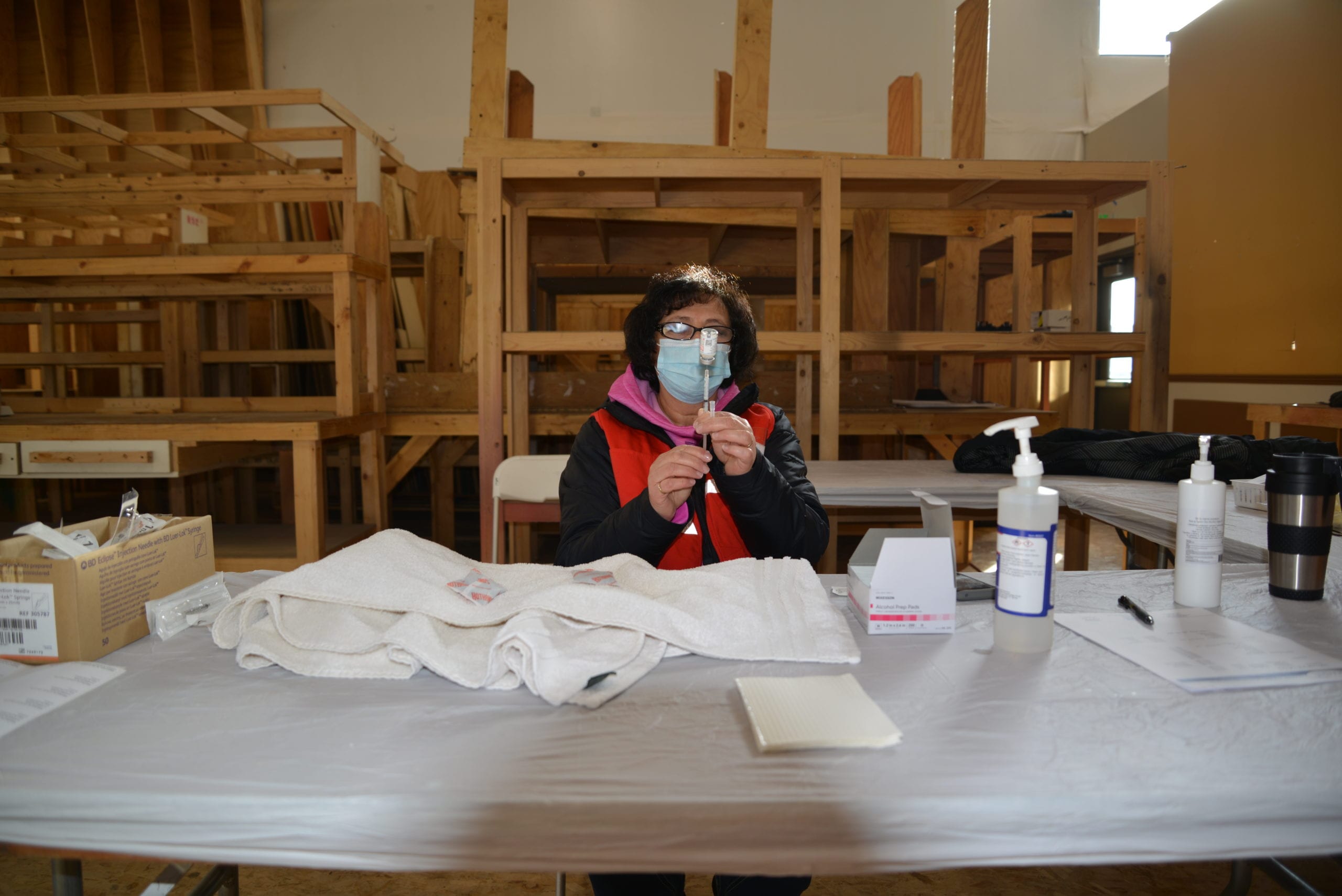 A vaccination clinic worker prepares the Moderna vaccine for use.