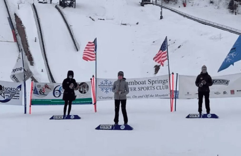 Josie Johnson atop the podium for the Women's U16 Ski jumping Jr. National Championships, masked and socially distanced.