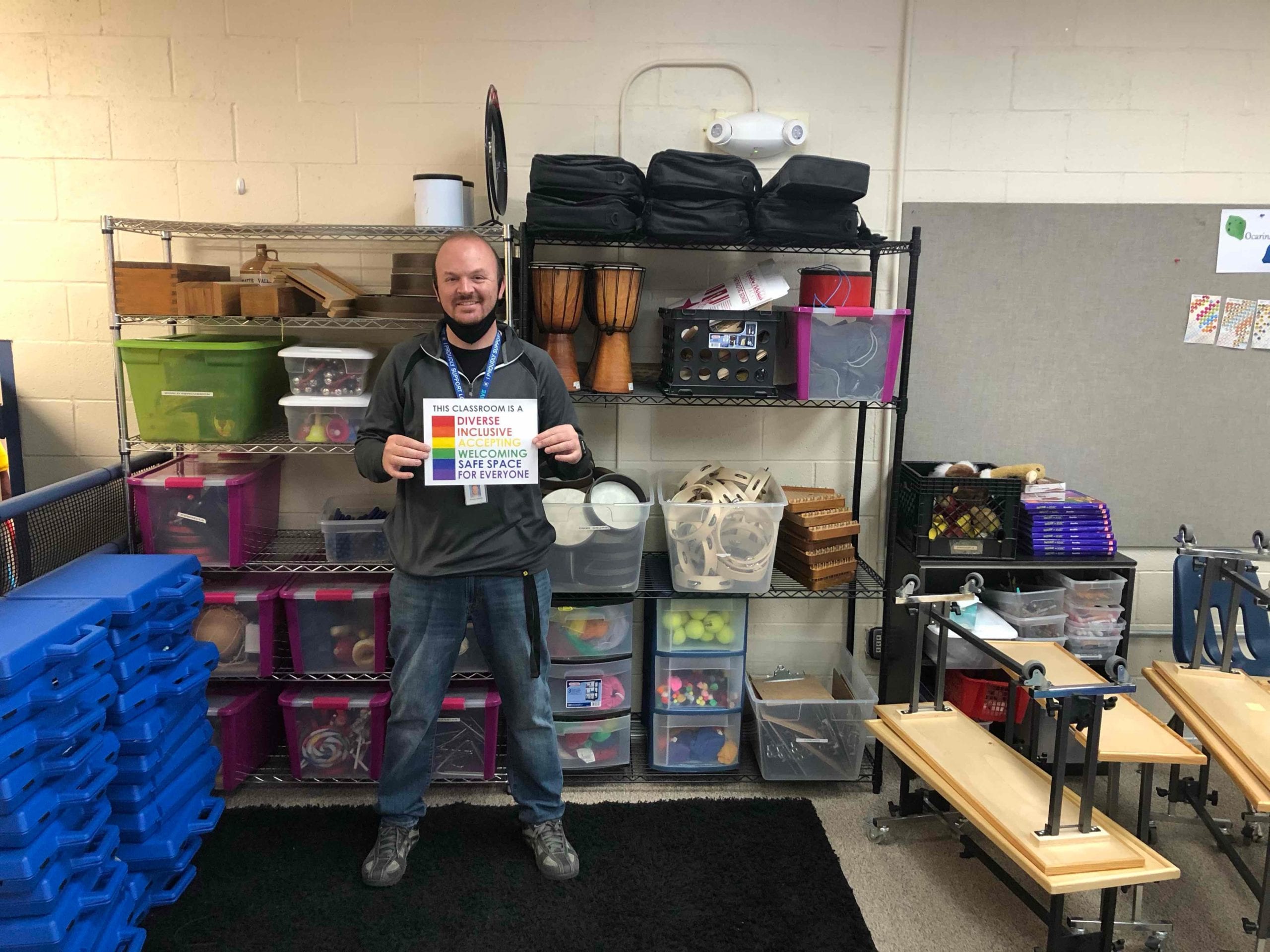 Aaron Webb, who teaches music at Parley's Park Elementary School and is vice president of the PCSD teacher's union, holding one of the signs displayed throughout the school.