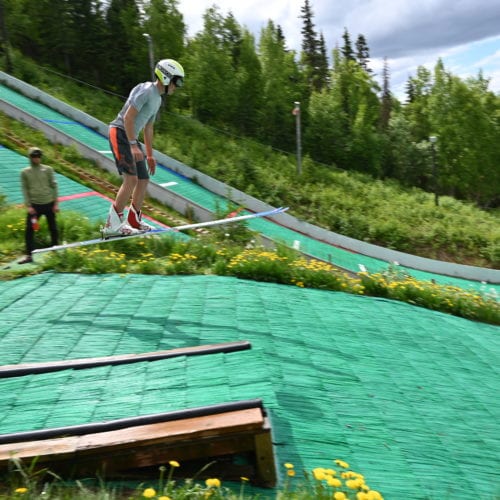 Tyler Phillips flying over coach Trevor Edlund in Alaska while warming up to jump the biggest hills on which he's more accustomed.