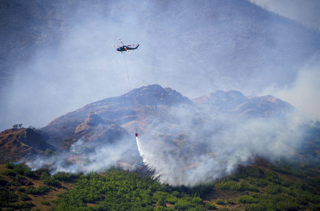A helicopter makes a drop on the East Canyon Fire as it burns north of East Canyon State Park, on Tuesday, June 8, near Morgan, Utah.