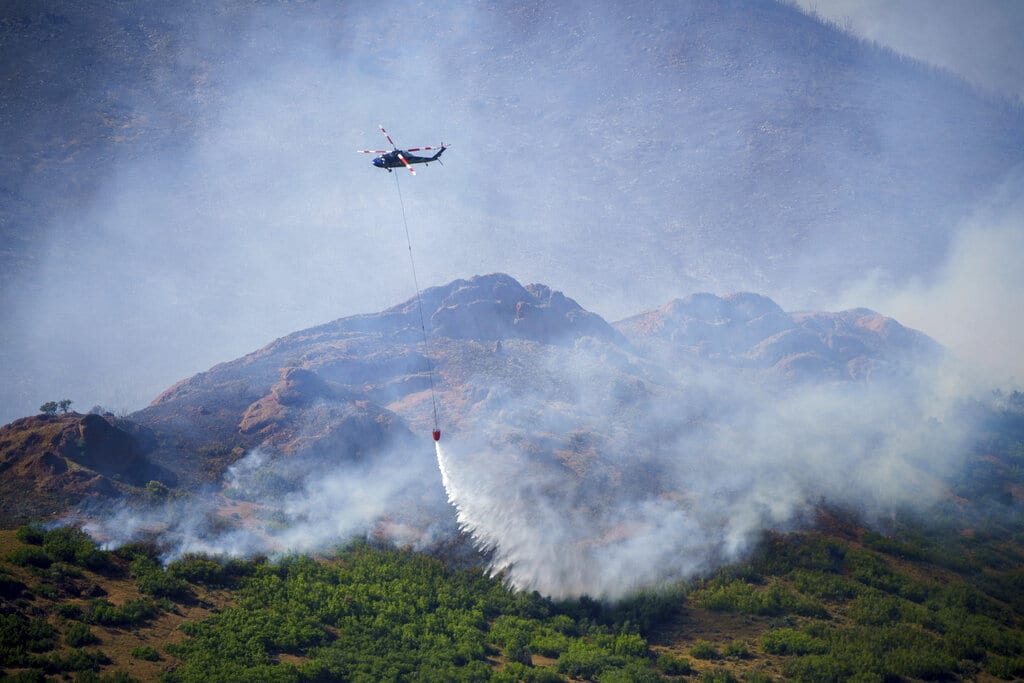 A helicopter makes a drop on the East Canyon Fire as it burns north of East Canyon State Park, on Tuesday, June 8, near Morgan, Utah.