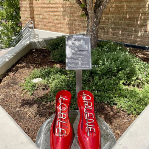 The red shoes created by local artist Zafod Beatlebrox beside the memorial plaque for Arlene Loble.