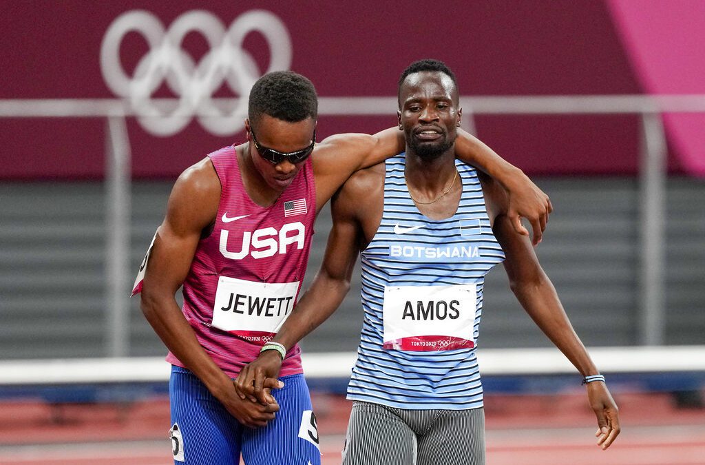 Isaiah Jewett, of the USA, and Nijel Amos, right, of Botswana, shake hands and cross the finish line together after falling together and helping each other up in the 800-meter semifinal at the 2020 Summer Olympics, Sunday, in Tokyo.