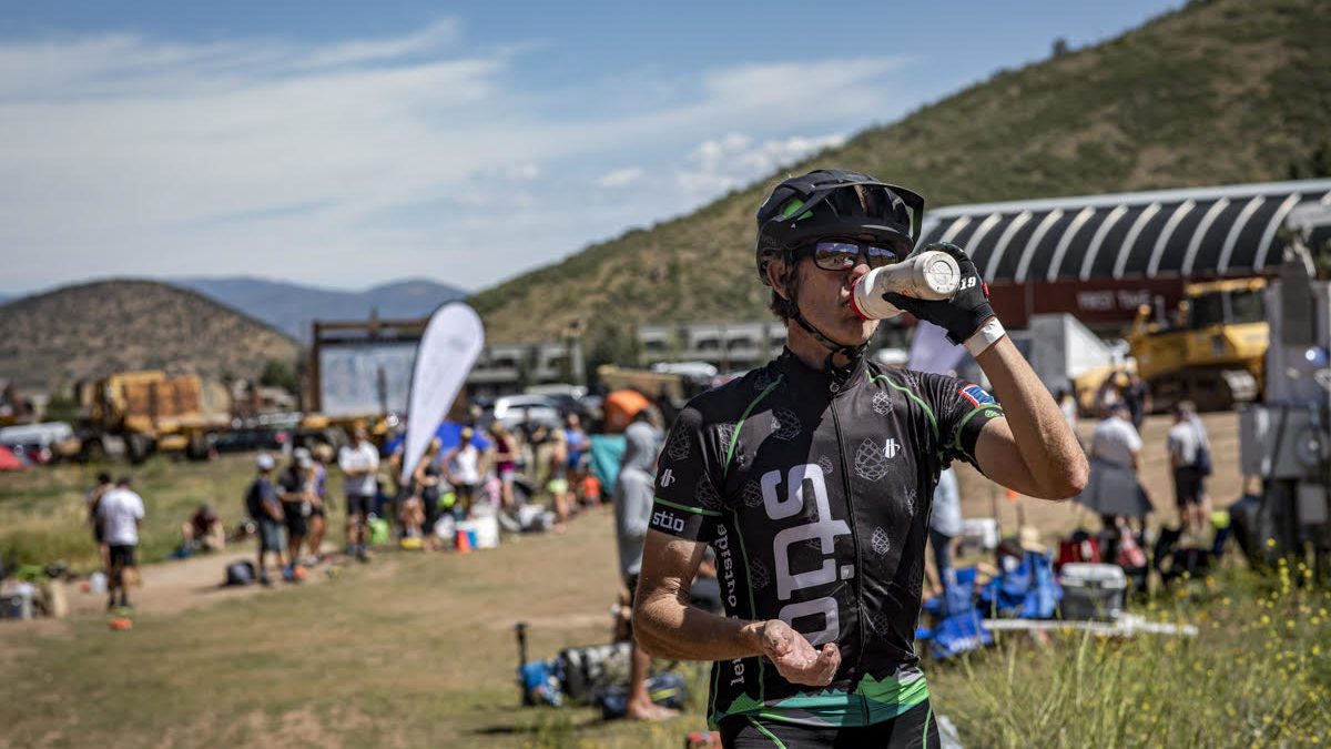 At mid-mountain, a biker (in Stio gear) takes a much needed water break before the last 20 miles of the Peak 2 Peak race.