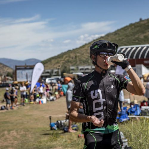 At mid-mountain, a biker (in Stio gear) takes a much needed water break before the last 20 miles of the Peak 2 Peak race.