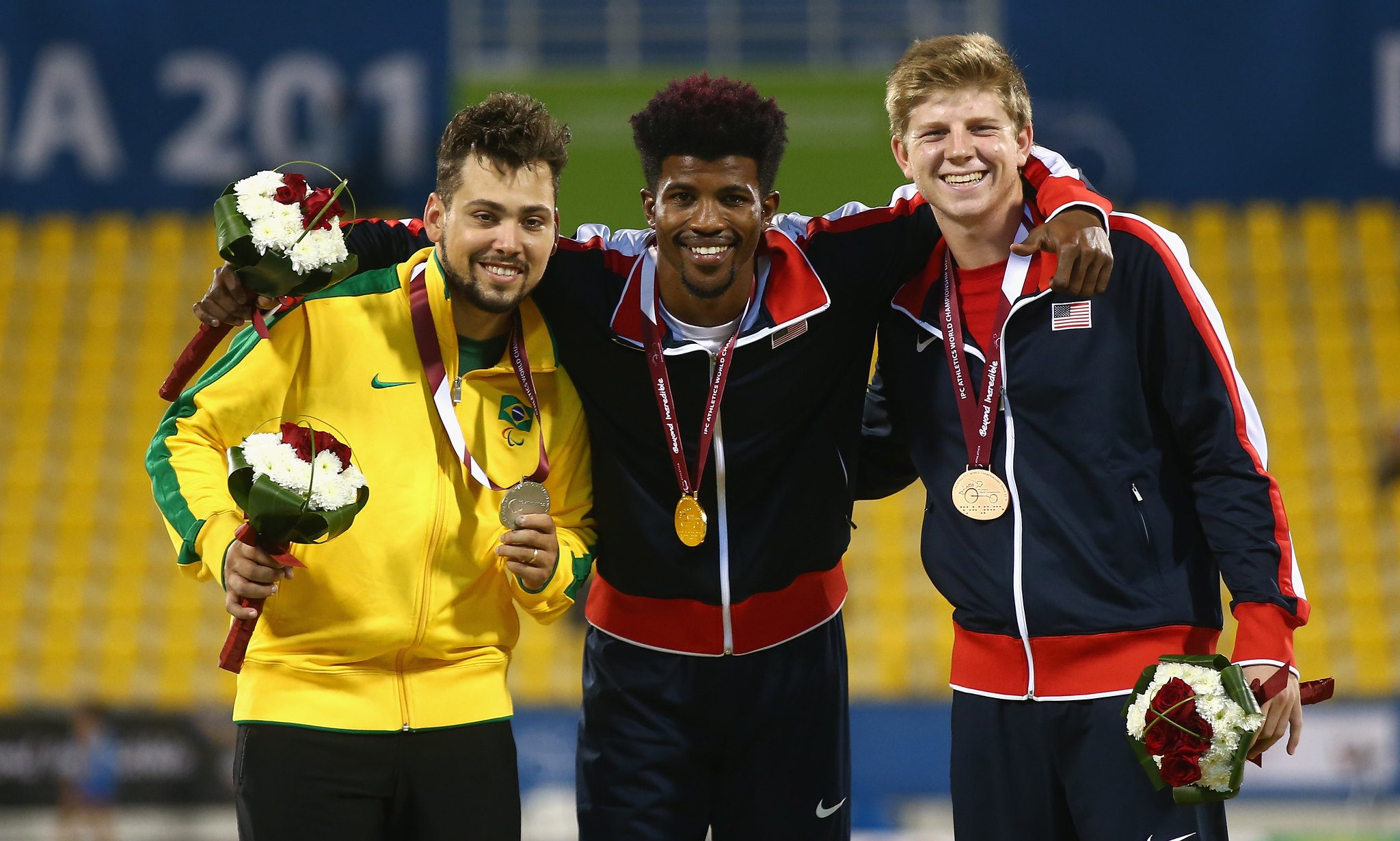 DOHA, QATAR - OCTOBER 25: Richard Browne of the United States poses with his gold, Alan Oliveira of Brazil silver and Hunter Woodhall of the United States bronze after the men's 200m T44 final during the Evening Session on Day Four of the IPC Athletics World Championships at Suhaim Bin Hamad Stadium on October 25, 2015 in Doha, Qatar.