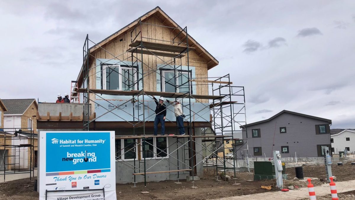 Habitat For Humanity's newest home in Park City with homeowner Chelsea Jones (L) and volunteer Casey Lebwohl (R) on the scaffolding.