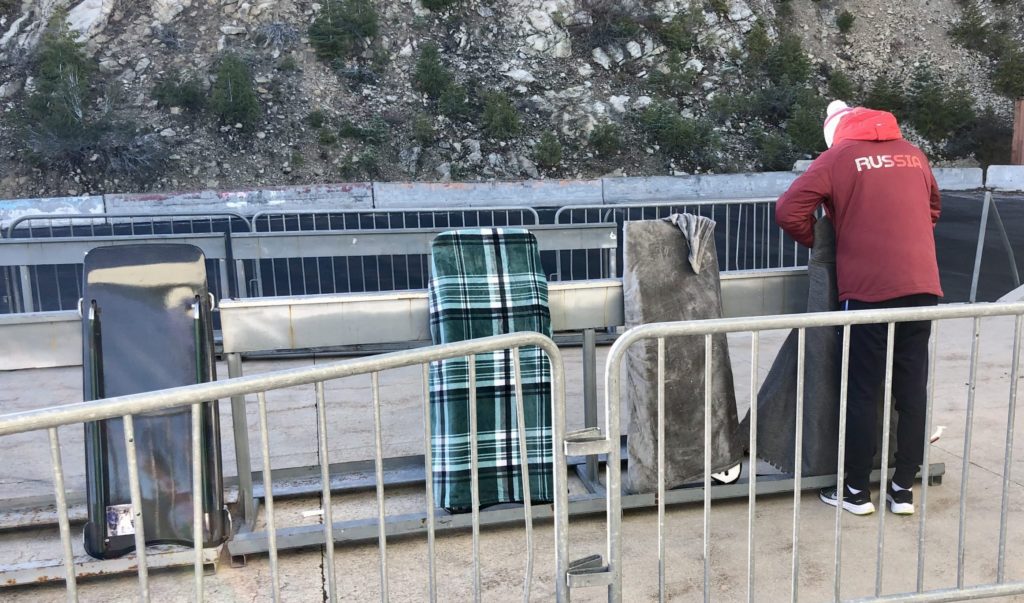 An athlete representing Russia set's his skeleton sled up into the staging area.