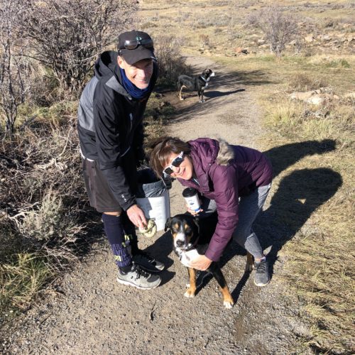 Milo, missing one eye due to cataracts, his furry friend Bella in the back, and their humans Chris and Melanie with the Golden Poop.