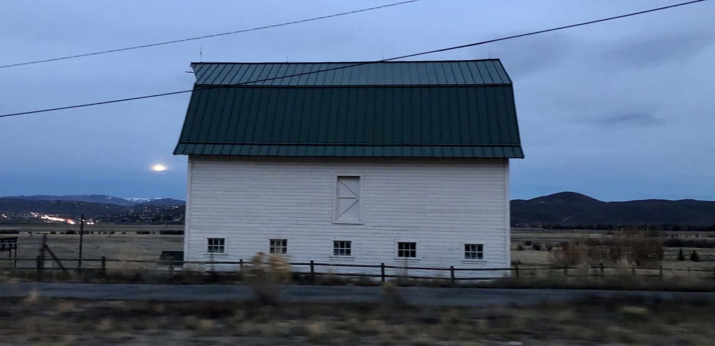 A full moon rising next to a barn in Summit County.