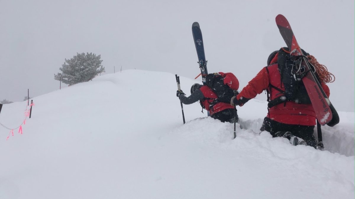 Ski patrollers boot-packing to the top of 9990 for avalanche mitigation work.