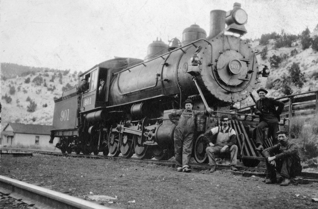 A D&RGW locomotive, with four men standing or sitting on or by the pilot (sometimes called a cow catcher), no date.