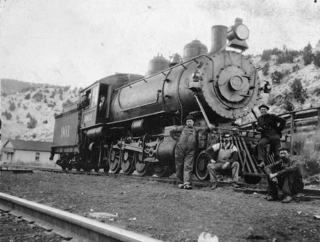 A D&RGW locomotive, with four men standing or sitting on or by the pilot (sometimes called a cow catcher), no date.