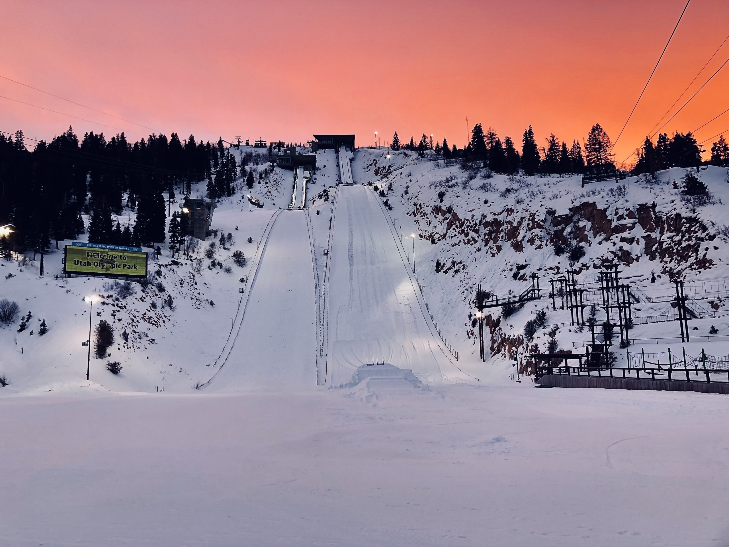 Sun sets behind the ski jumps at the Utah Olympic Park. Venues like the UOP will host more events in 2034 than they did at the 2002 Games. Ski Jumping is a good axample of this as women's ski jumping was not a part of the 2002 Olympics.