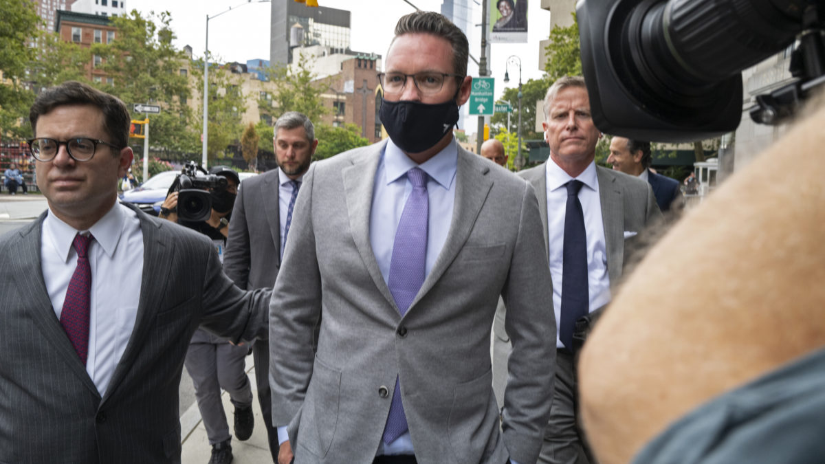 Nikola founder Trevor Milton, center, leaves a federal courthouse in New York on July 29, 2021, after being charged with three counts of criminal fraud for lying to bolster stock sales of the electric vehicle start-up Nikola.