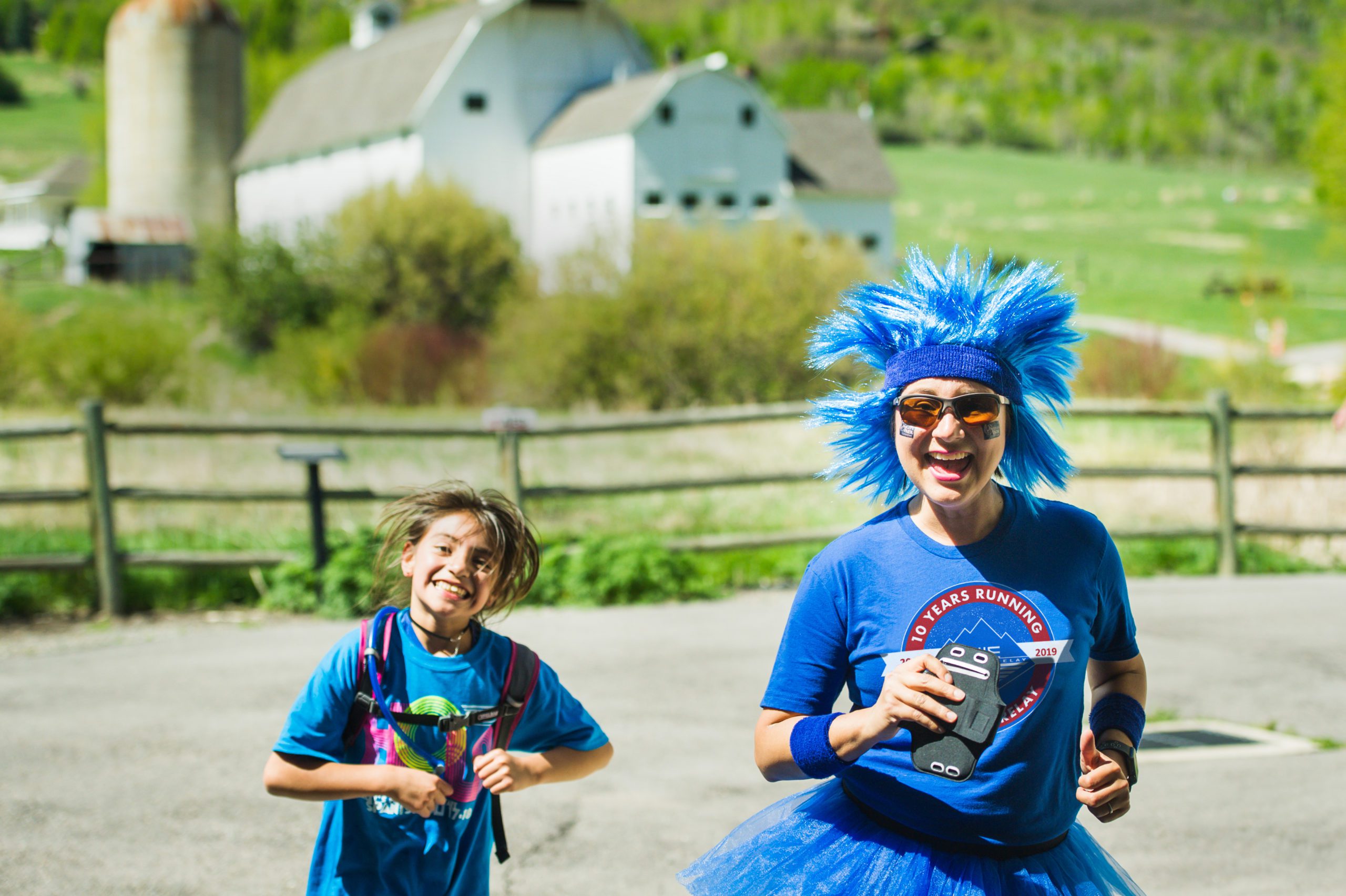 Park City School District teacher Vicky Rudolph Running with Ed alongside a student at the white barn.