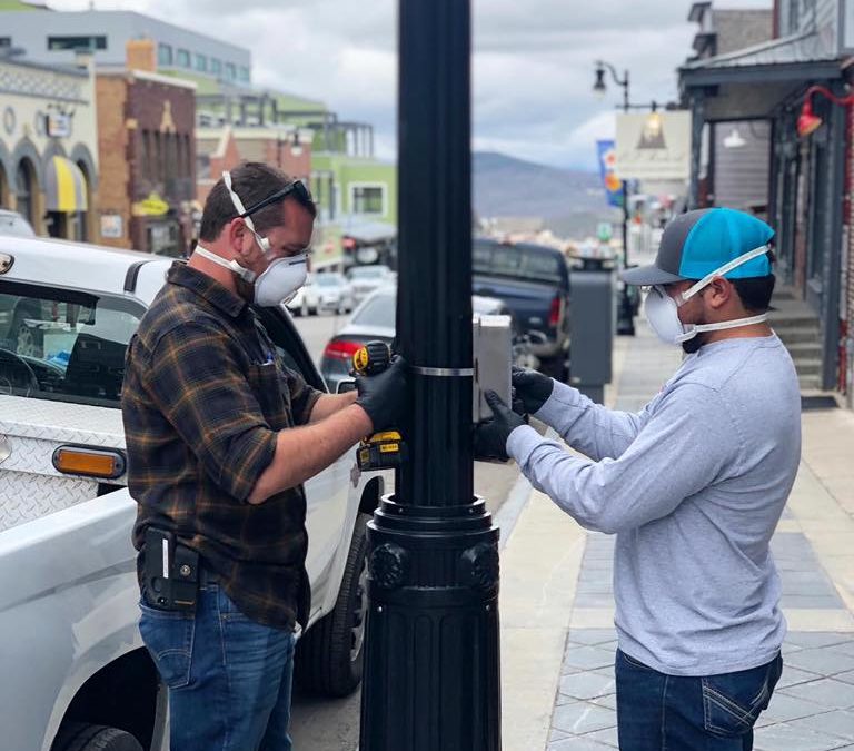 Installing a government-sponsored hand sanitizer dispenser on Park City's Main Street in May 2020.