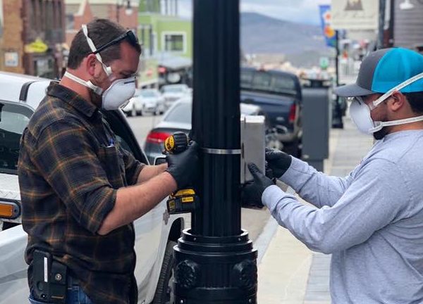 Installing a government-sponsored hand sanitizer dispenser on Park City's Main Street in May 2020.