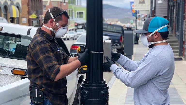 Installing a government-sponsored hand sanitizer dispenser on Park City's Main Street in May 2020.