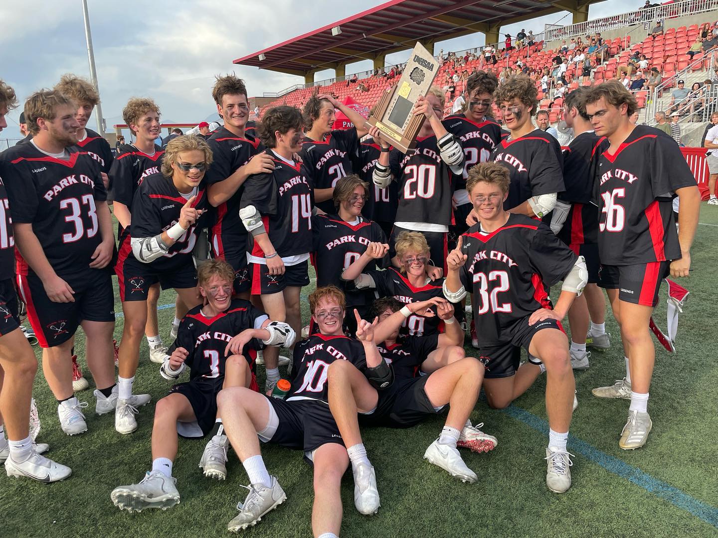 Park City Boys High School Lacrosse players hoisting the team trophy.