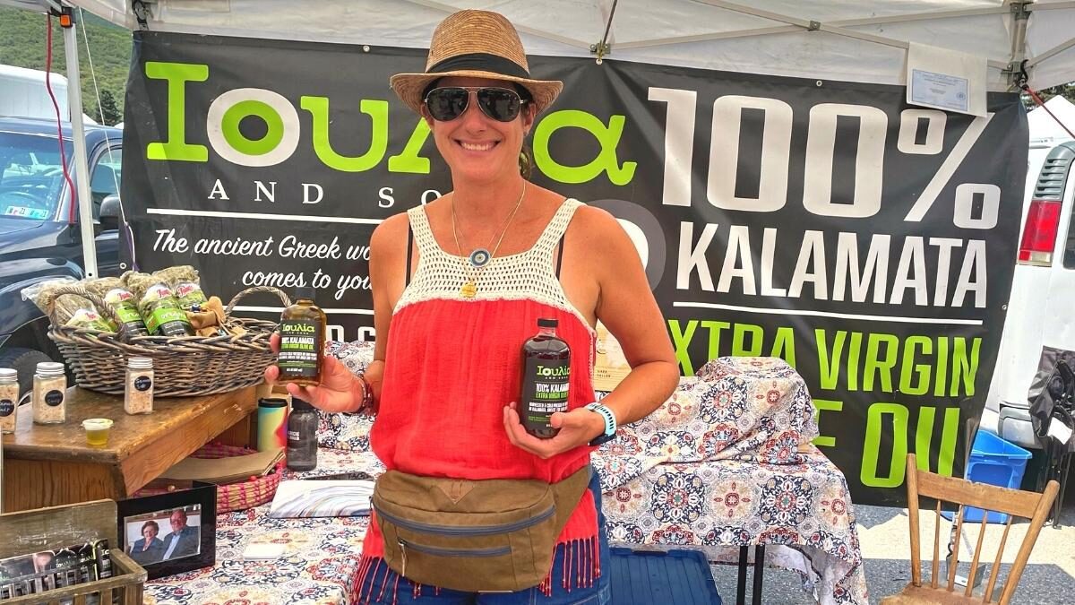Christina Bhanos displaying Ioulia Greek Olive Oil at the Park City Farmers Market.