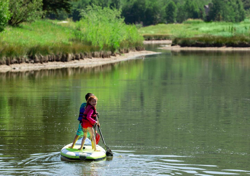 Individuals of all ages and abilities can participate in paddleboarding and kayaking in a peaceful setting at Deer Valley's Pebble Beach.