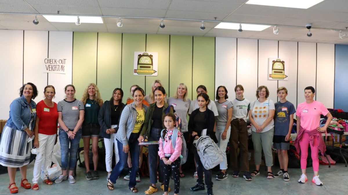 Camila, Alexa, Romina, and mom Rafaela pose with the Back 2 School Basics volunteers after picking out brand new school supplies.