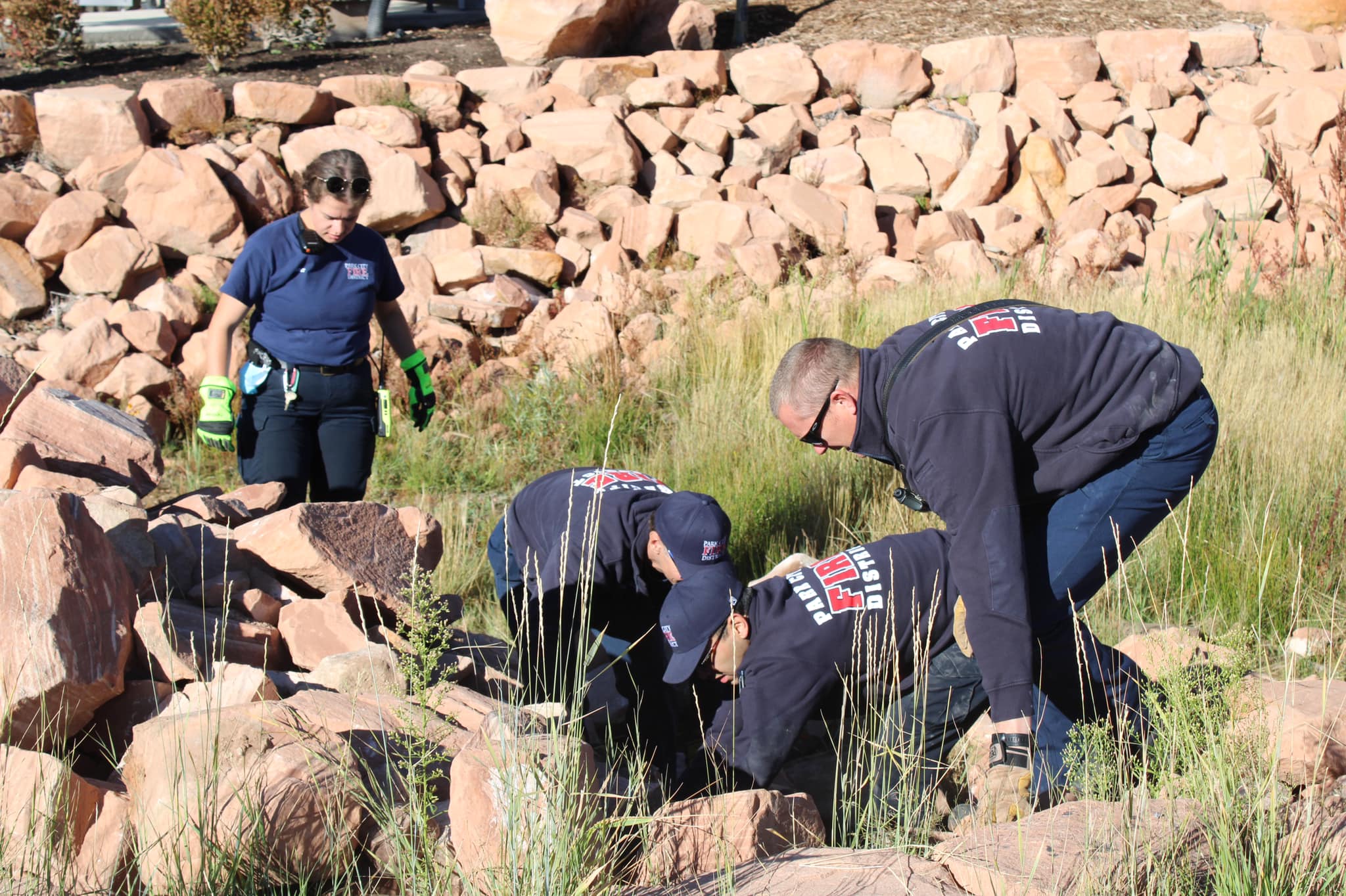 Firefighters and EMTs working to remove boulders to rescue Lola