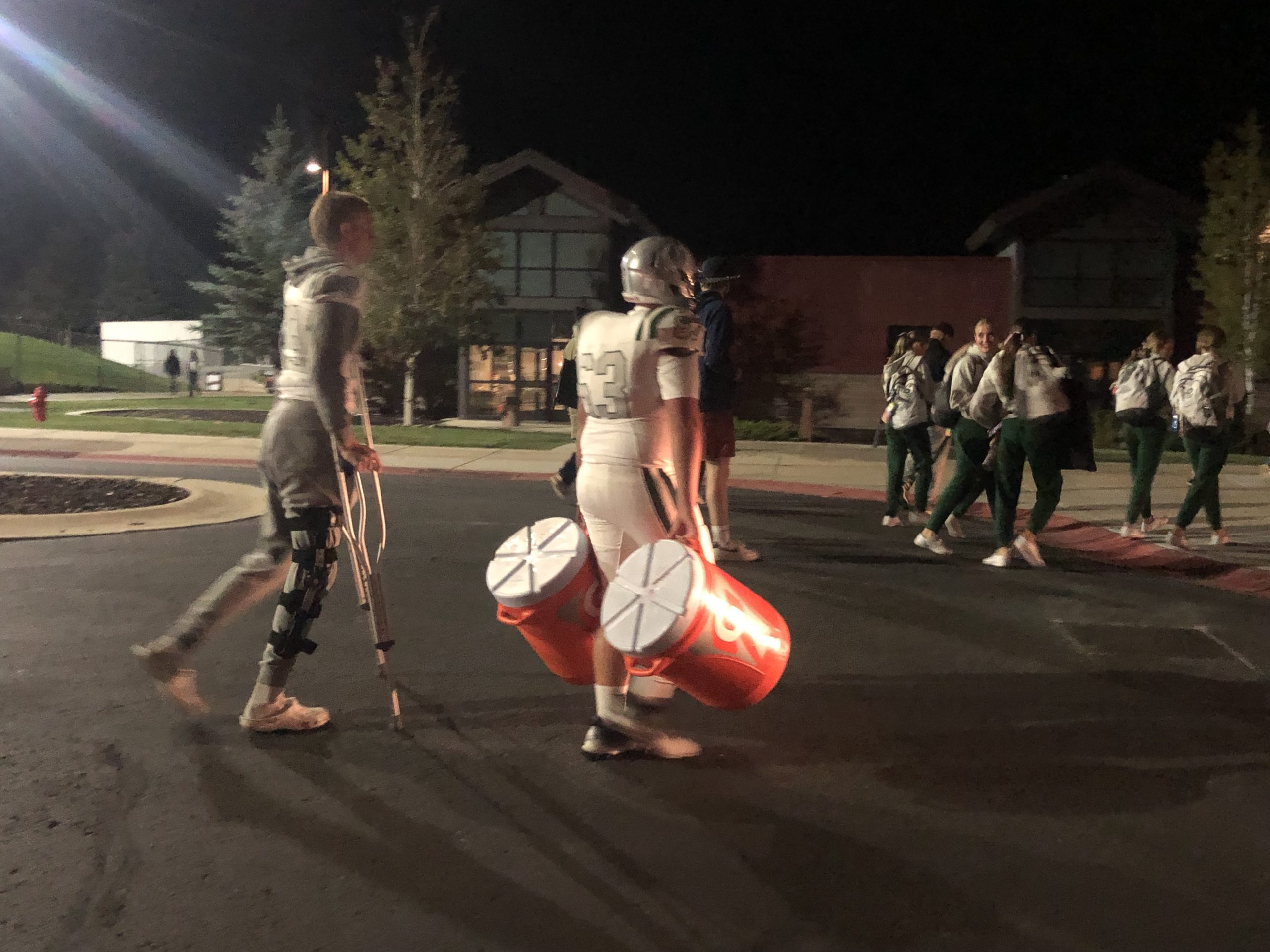 Olympus High School cheerleaders, football player and benched athlete walking back to their Team Bus to drive to Salt Lake City after a defeat by Park City High.