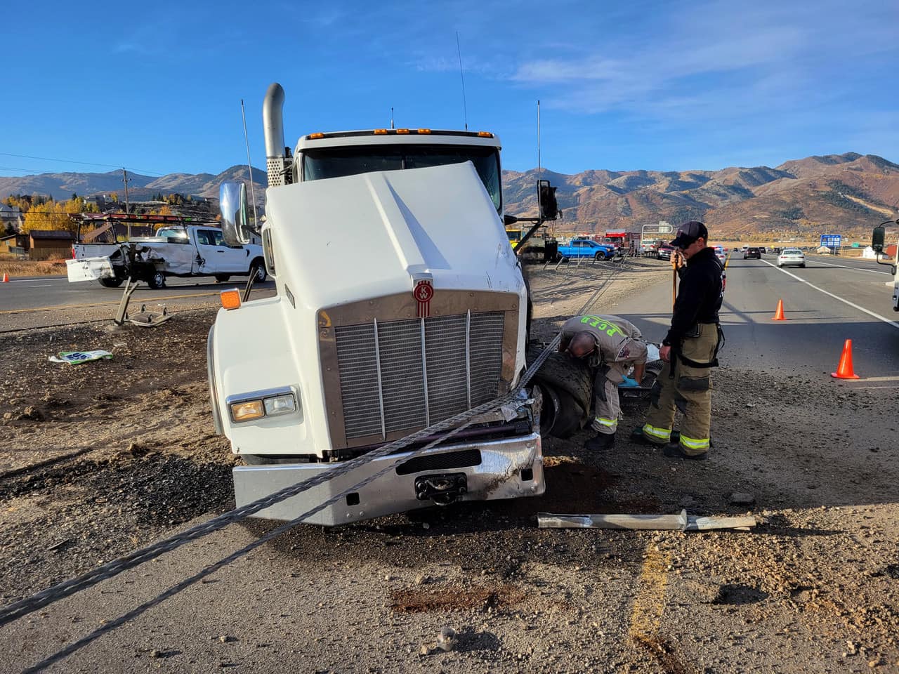 Damaged dump truck with first responders on scene