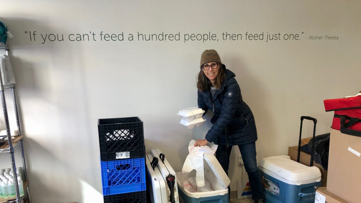 Working under the quote painted on the wall at the Christian Center by Mother Theresa, "If you can't feed a hundred people, then feed just one," Volunteer Tina Quayle picks up food to deliver to local seniors via Meals on Wheels.