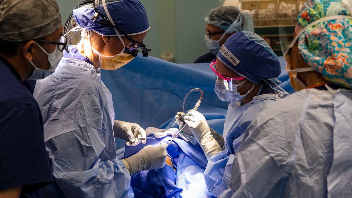 Tamara Kemp, left, and Maria Nadale, right, perform surgery on a young Colombian patient aboard Comfort, Nov. 17, 2022.