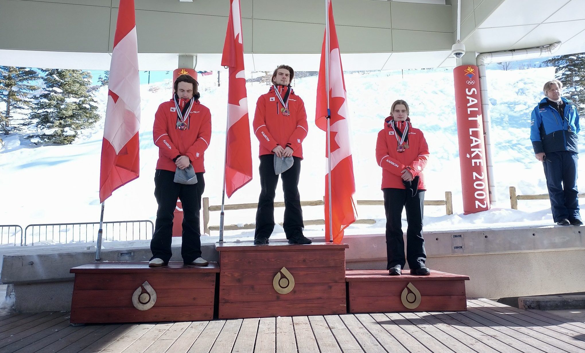 Canada sweeps multiple podiums at the Utah Olympic Park for a Continental Cup race on Saturday as Wasatch Luge Program Director, Race Technical Director, Podium Ceremony Announcer and Olympian Jon Owen looks on.