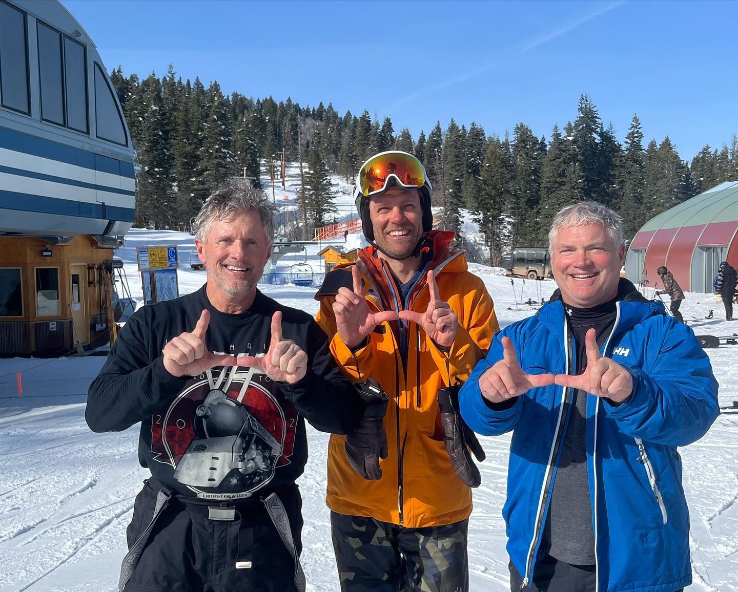 (L-R) University of Utah Football Coach Kyle Wittingham, US Ski Team racer Steven Nyman, and U of U Coach Freddie Wittingham skiing together in Utah in February and flashing the "U."