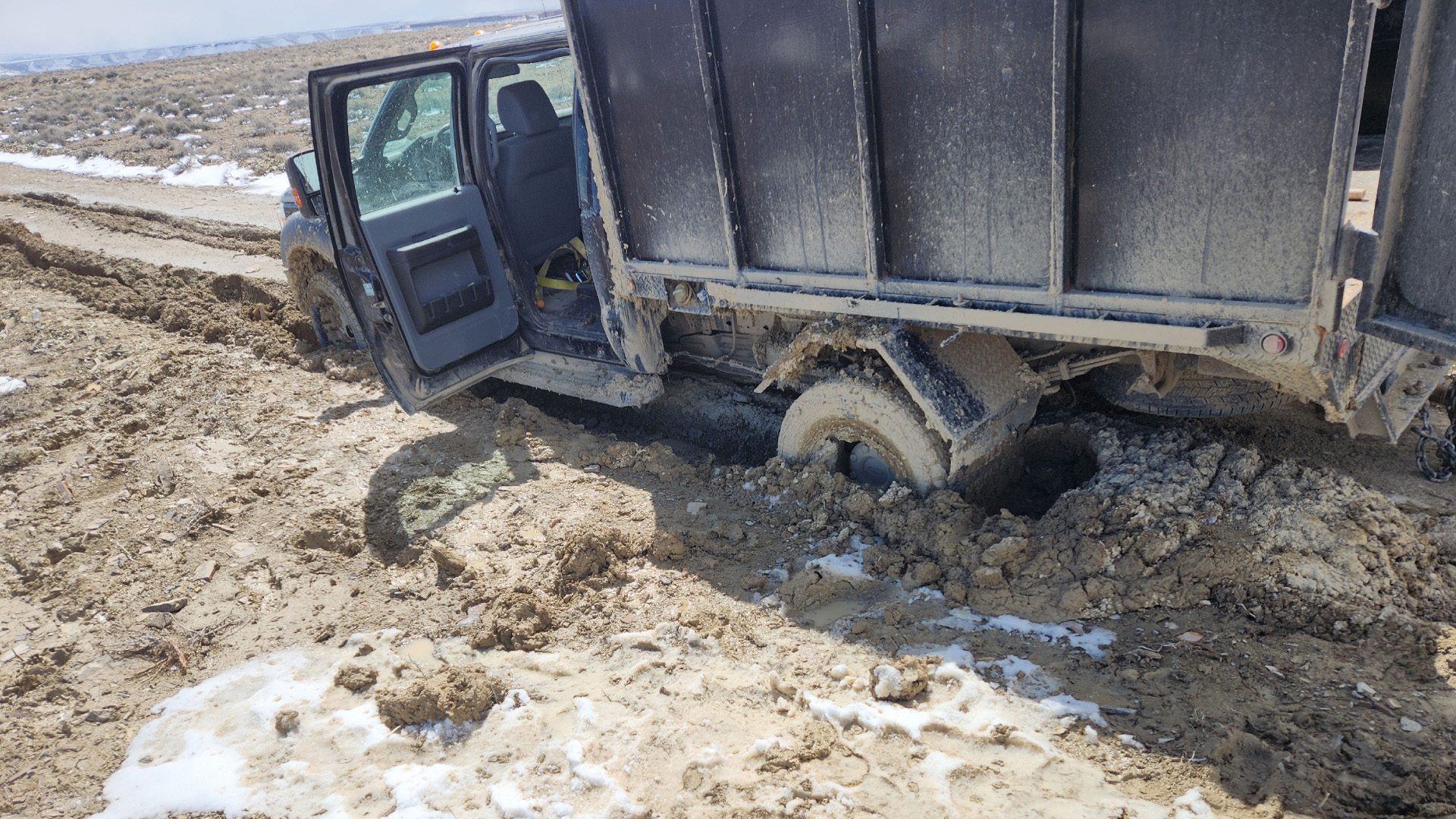 A truck buried to the frame in mud.