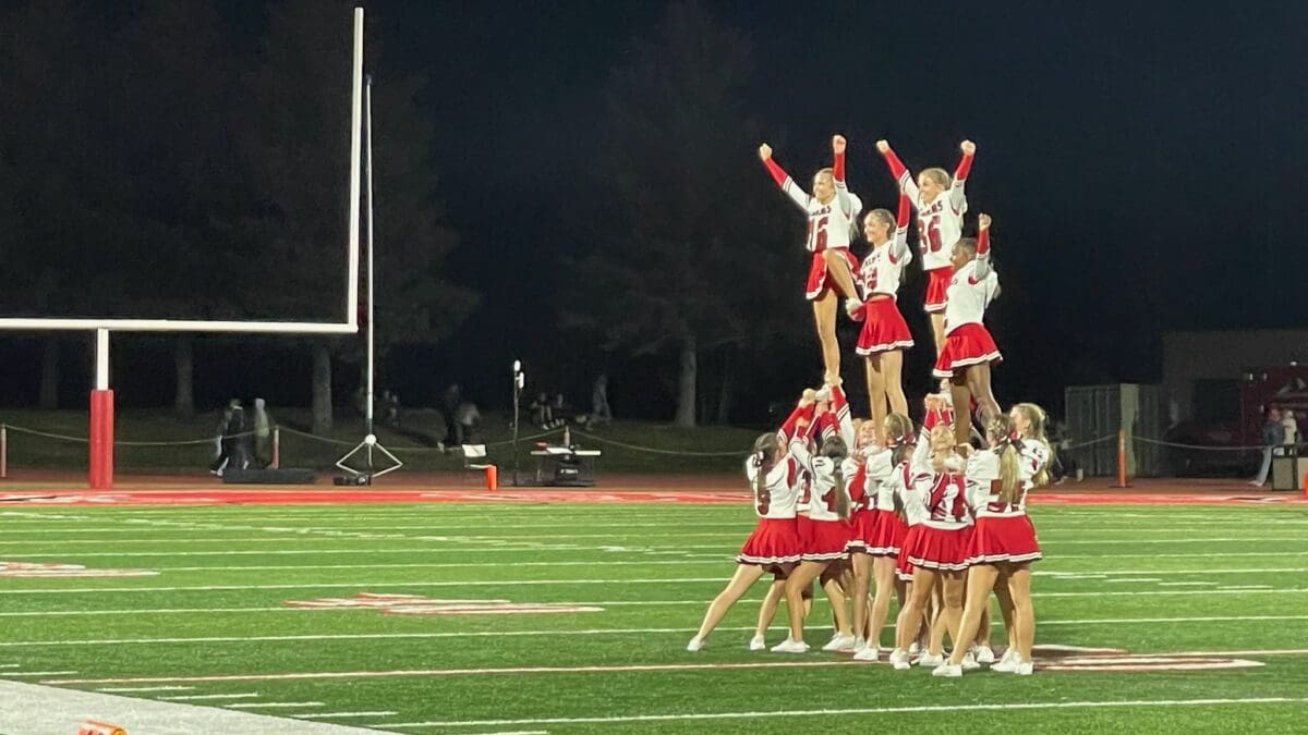 Cheer squad for the Park City High School Miners performing at the football game halftime show for a packed crowd at Dozier Field.