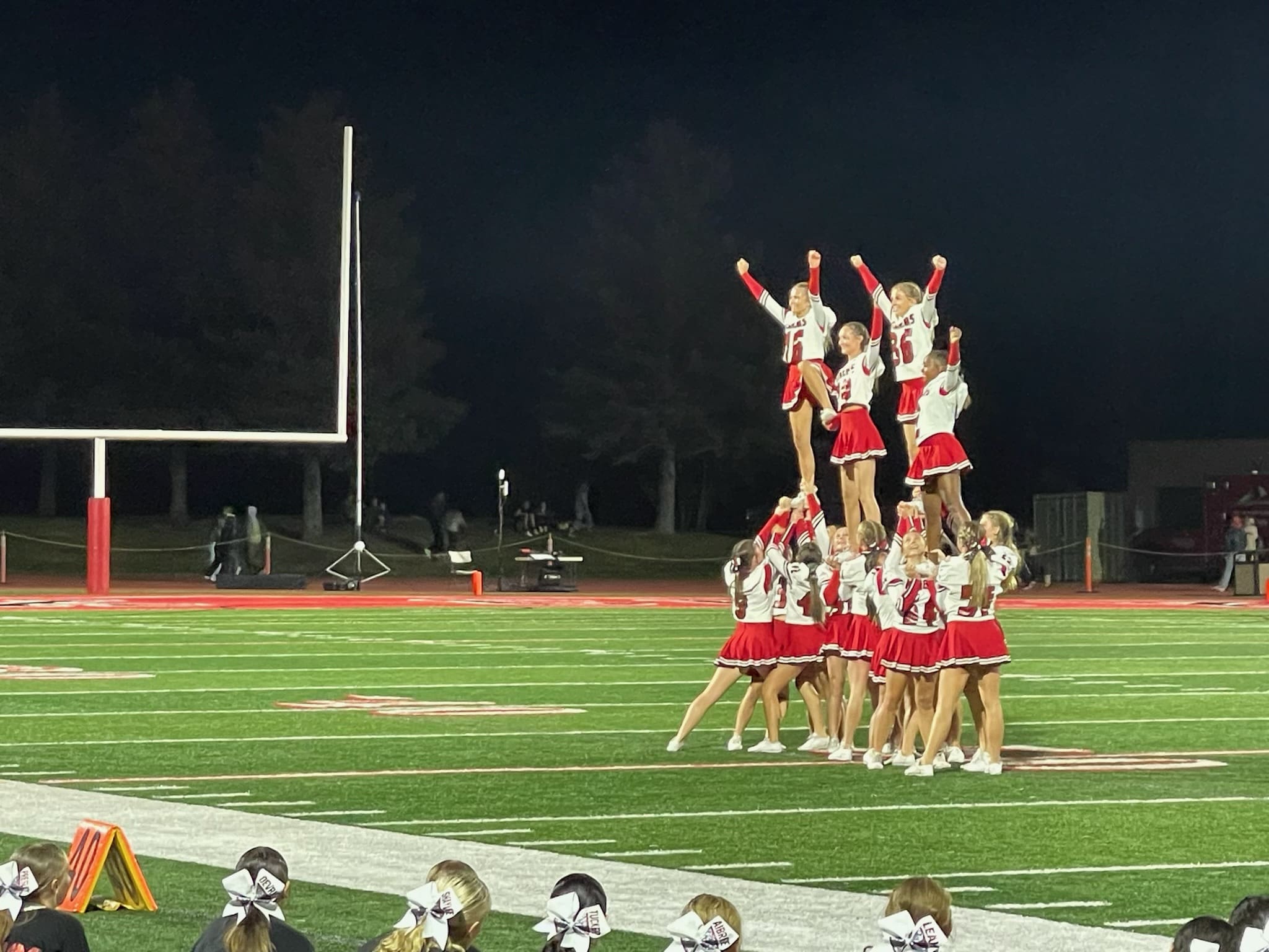 Cheer squad for the Park City High School Miners performing at the football game halftime show for a packed crowd at Dozier Field.