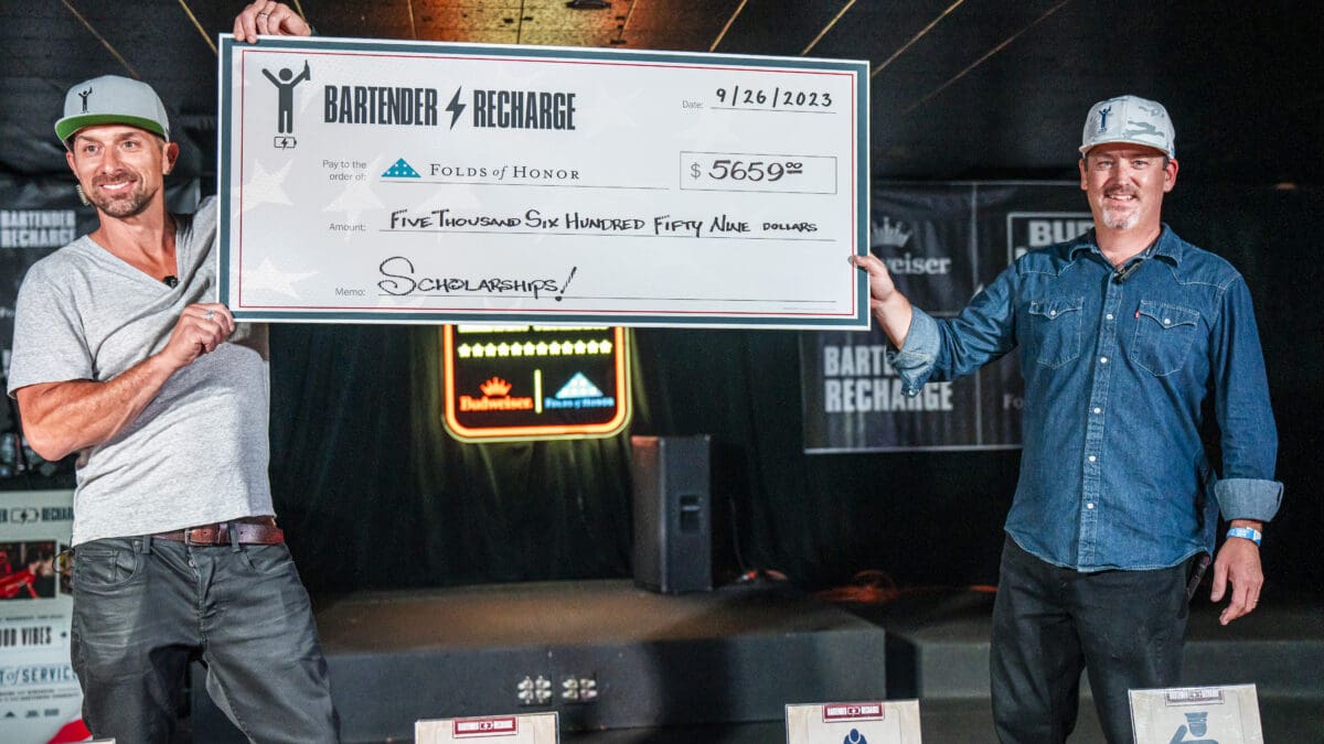 Seth Hill and Casey Metzger present check at the annual Bartender Recharge event.