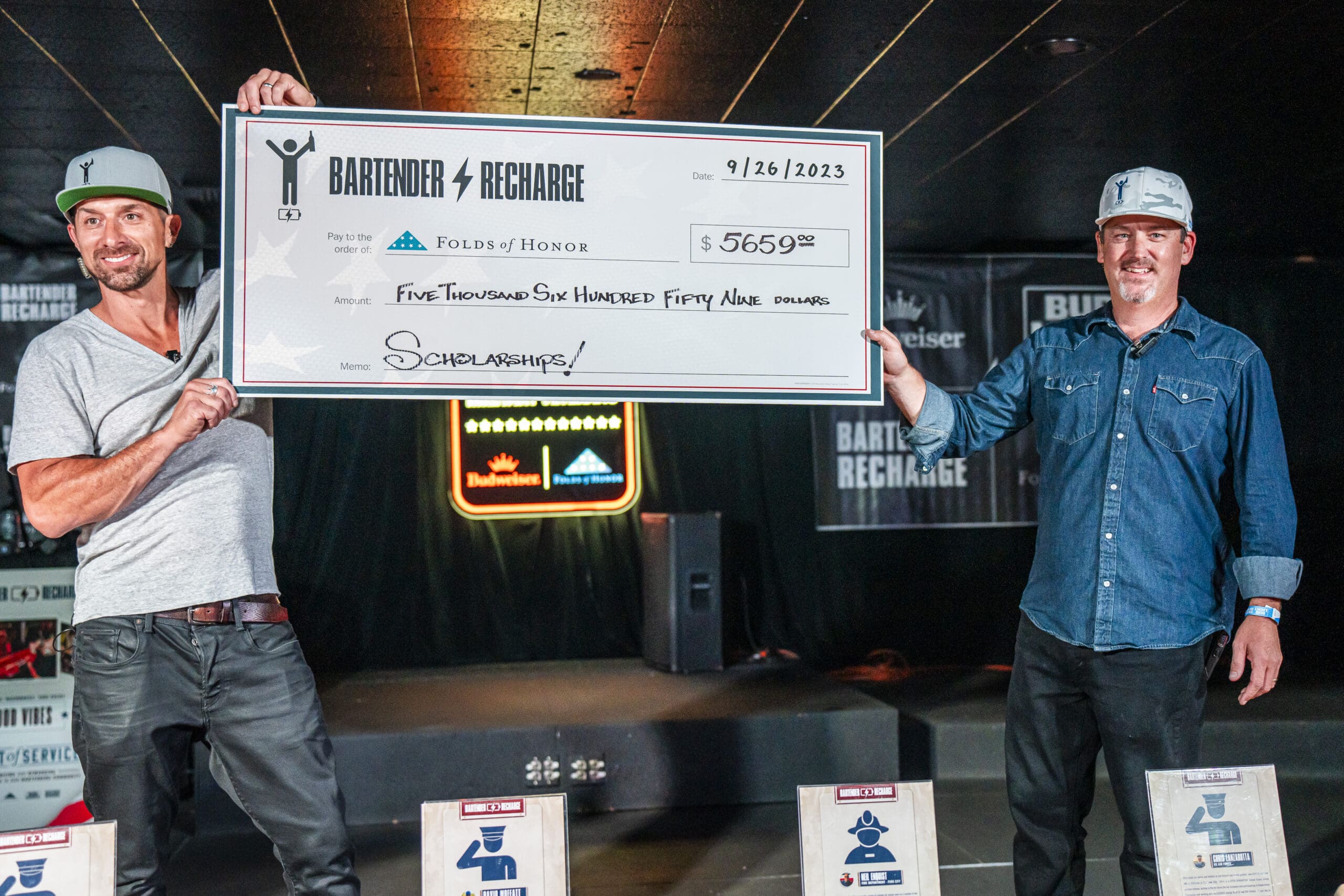 Seth Hill and Casey Metzger present check at the annual Bartender Recharge event.