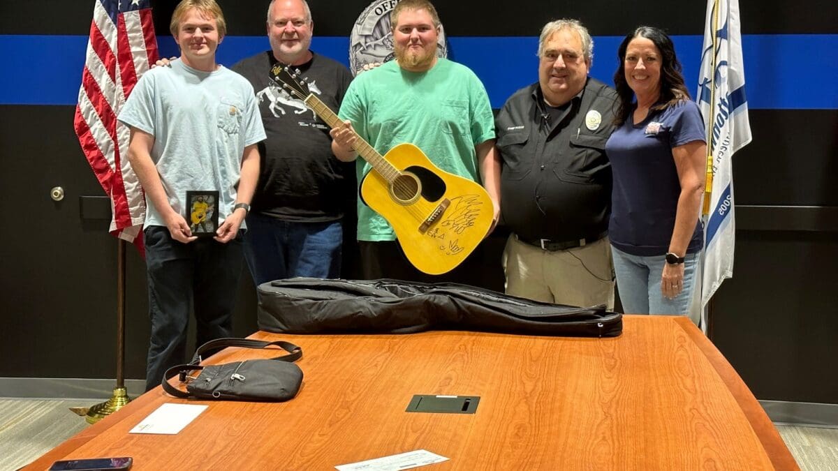 Chris Nelson, center, was the winner of a signed Post Malone guitar with a $15,500 bid.