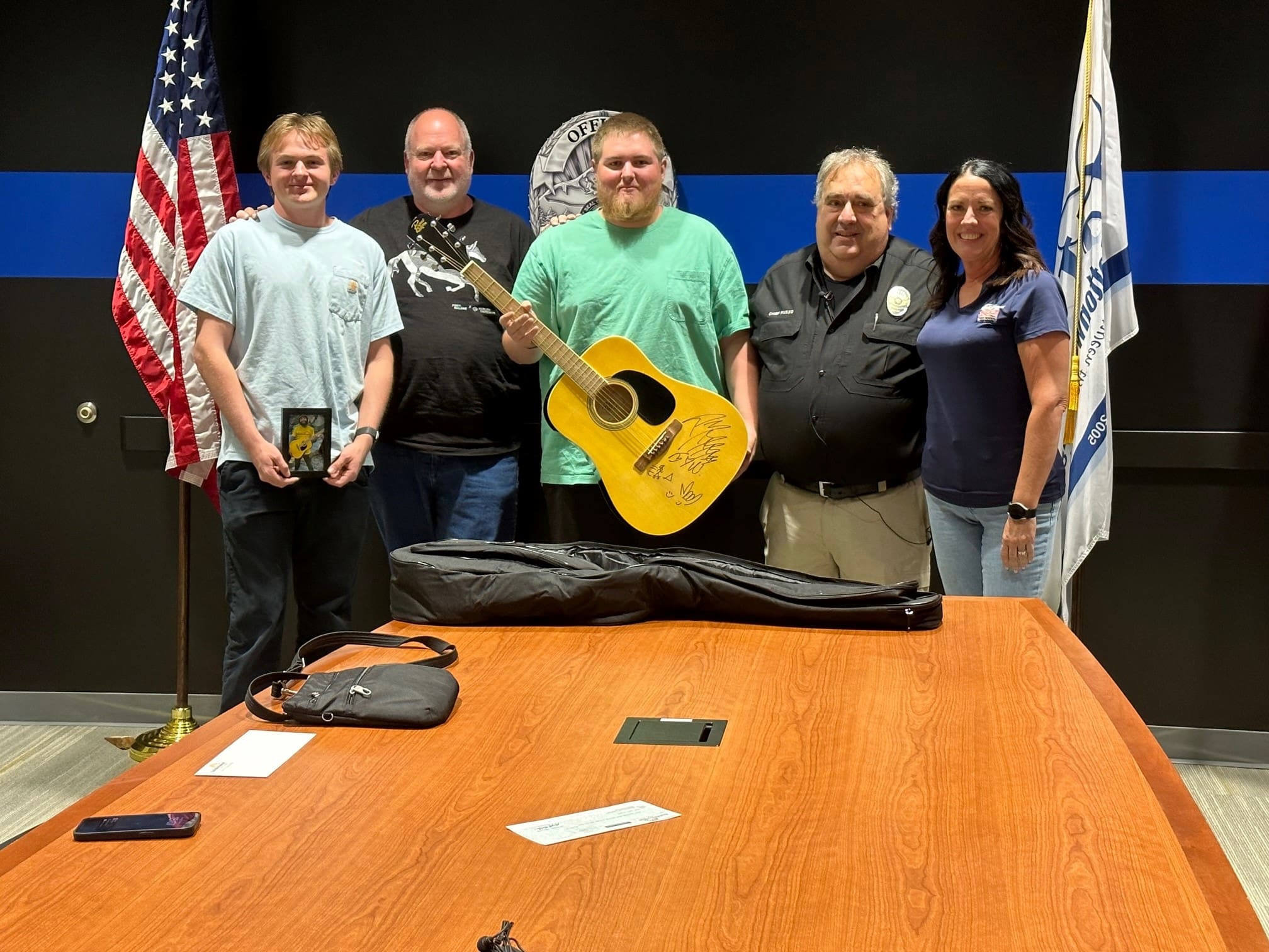 Chris Nelson, center, was the winner of a signed Post Malone guitar with a $15,500 bid.