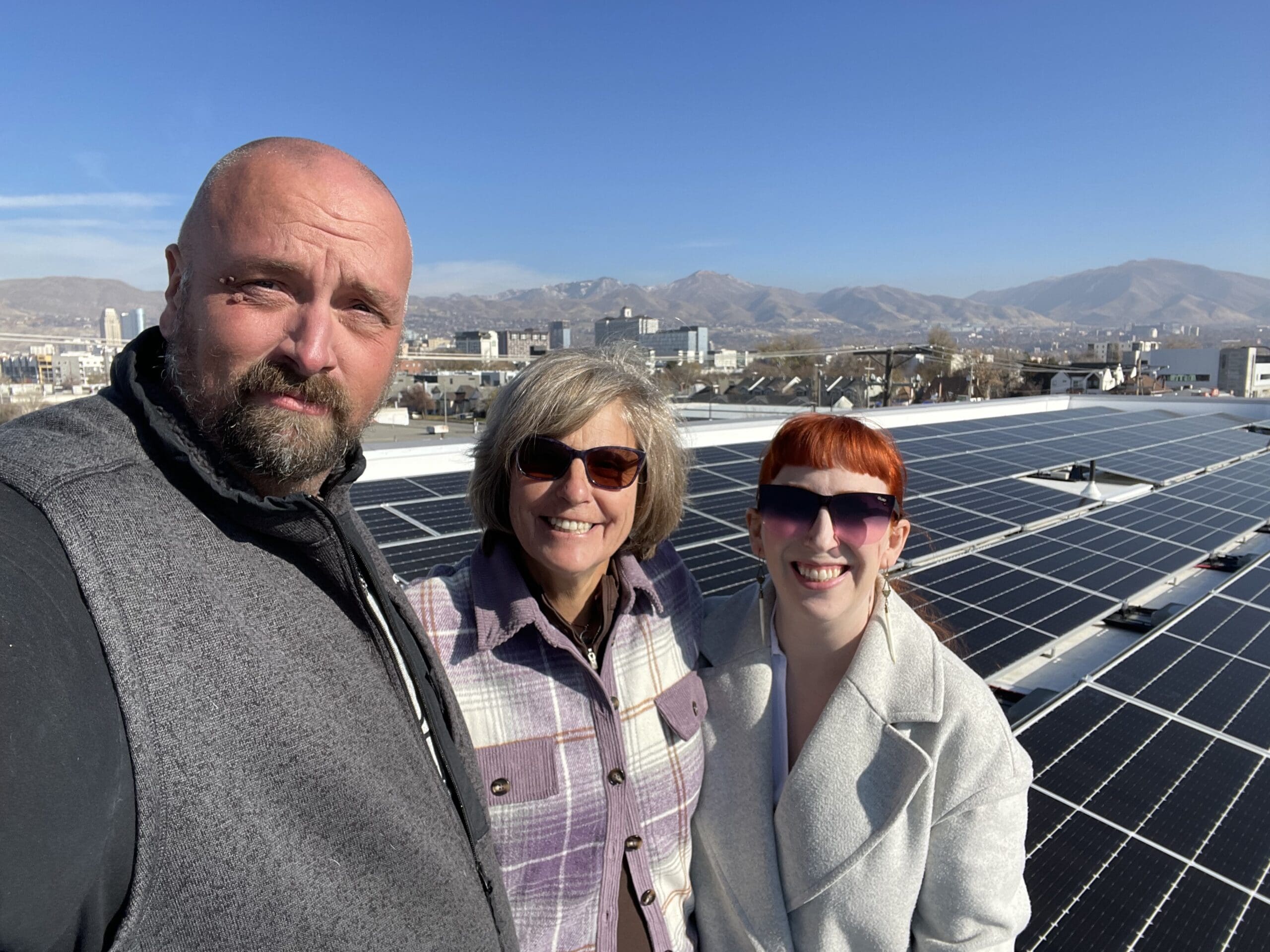 Executive Director, Park City's Donna Matturro McAleer standing in between Steve Welch, R&O Construction Superintendent, and Ashley Iordanov, Principal Architect, Atlas Architects at the 141 solar panels on the new Bicycle Collective building in Salt Lake City.