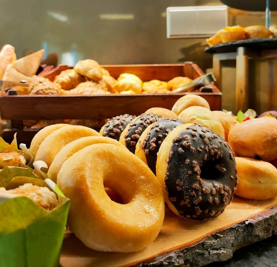 a variety of doughnuts are displayed in a bakery