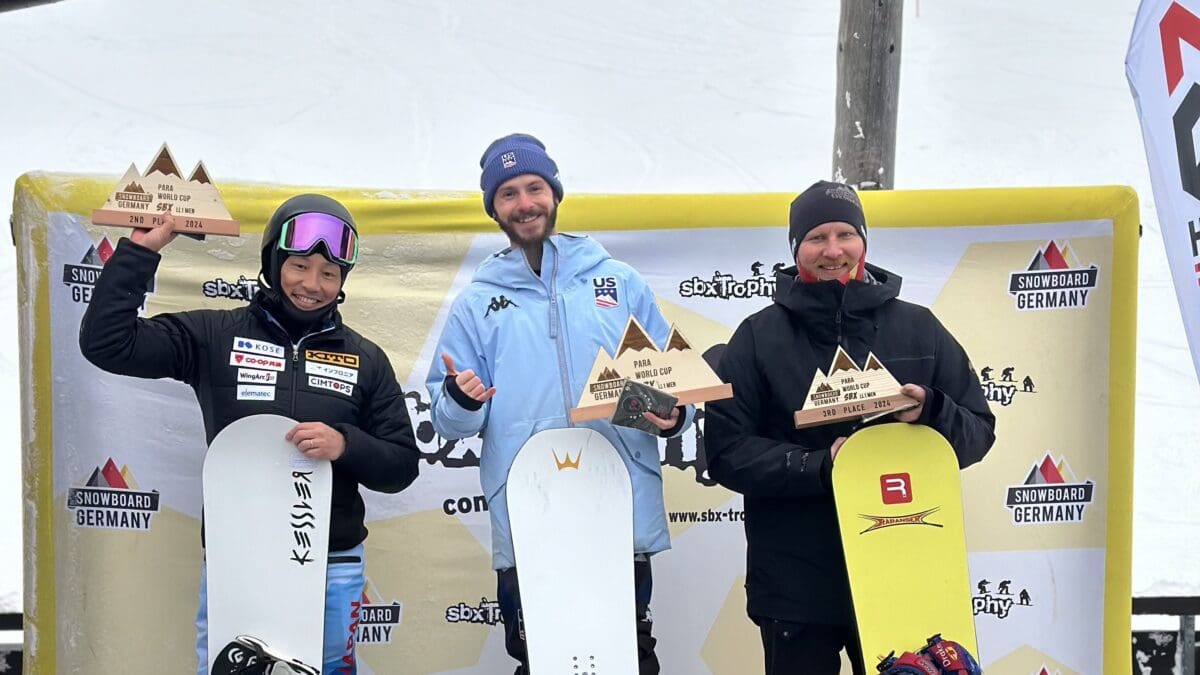 Noah Elliott of the U.S. Para Snowboarding Team stands atop the podium in Germany, following his back-to-back snowboard cross wins. Not pictured, Brenna Huckaby, Kate Delson, or Keith Gabel on the podium at the same competition.