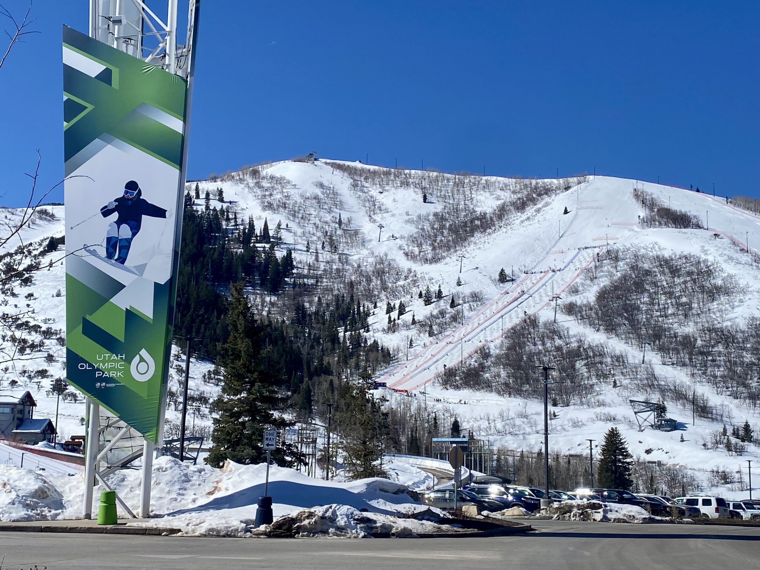 Art imitating life or life imitating art with moguls signage in the foreground and the first moguls competition in the background at the Utah Olympic Park's private new ski section for Jr. Freestyle National Championships.