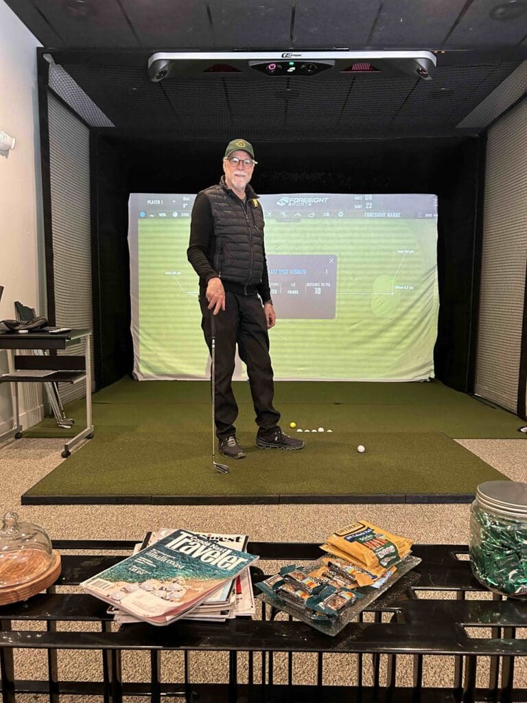 30-Minute Tire owner Steve Stanton at their golf simulator, which is available for use by customers while waiting for their tire services to be done.