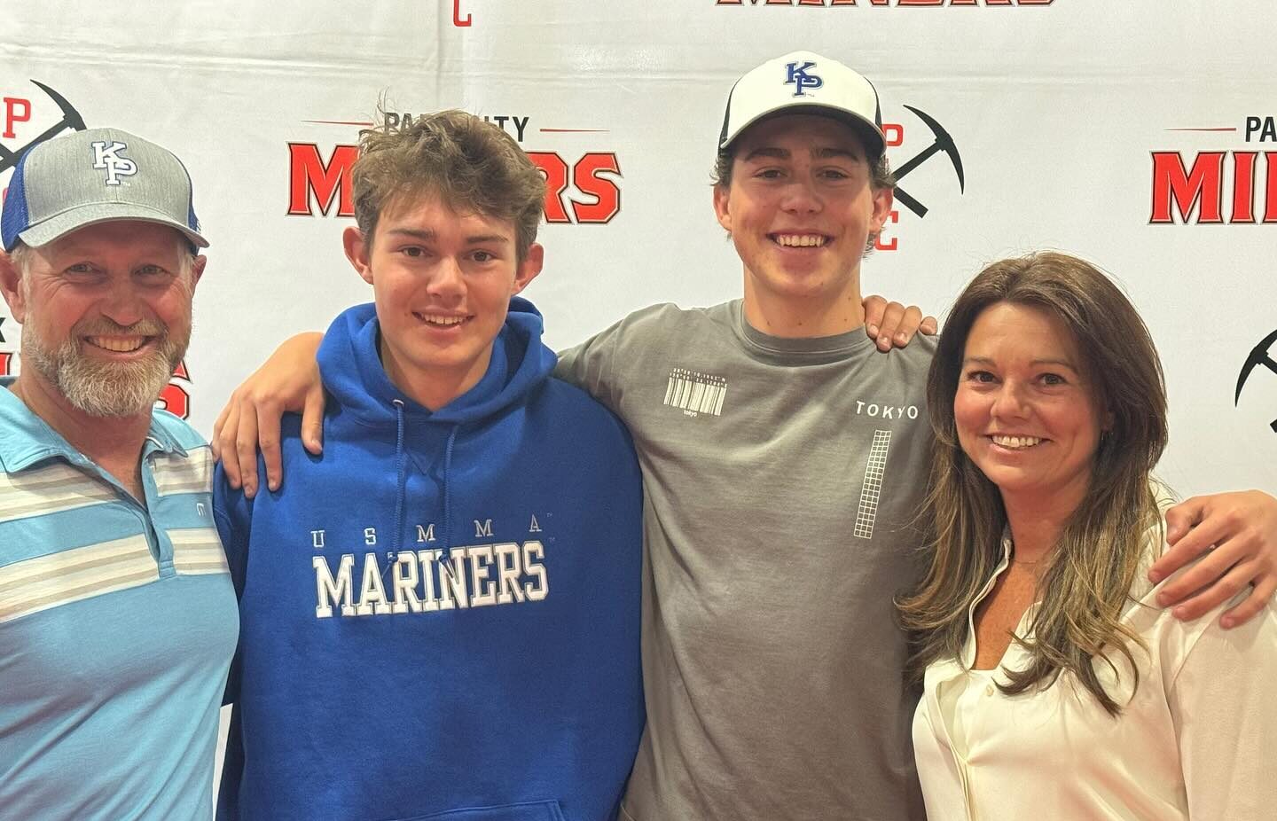 (R-L) Dad, Joel; Calvin; younger brother and PCHS Junior, Jeremiah; and Mom, Casey Marsh at Calvin's college signing day. In this photo taken at Park City High School, Calvin's dad and brother are wearing hats from his new school at King's Point (KP).